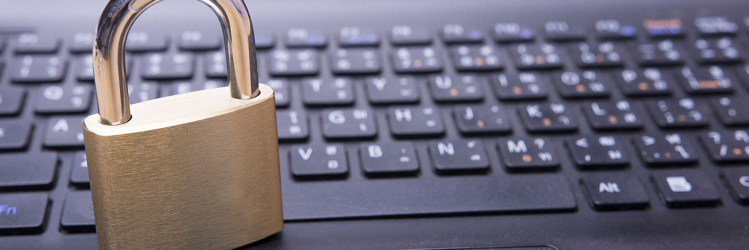 Close-up of a padlock on a laptop keyboard symbolizing cybersecurity, data protection, online privacy, and secure digital access.